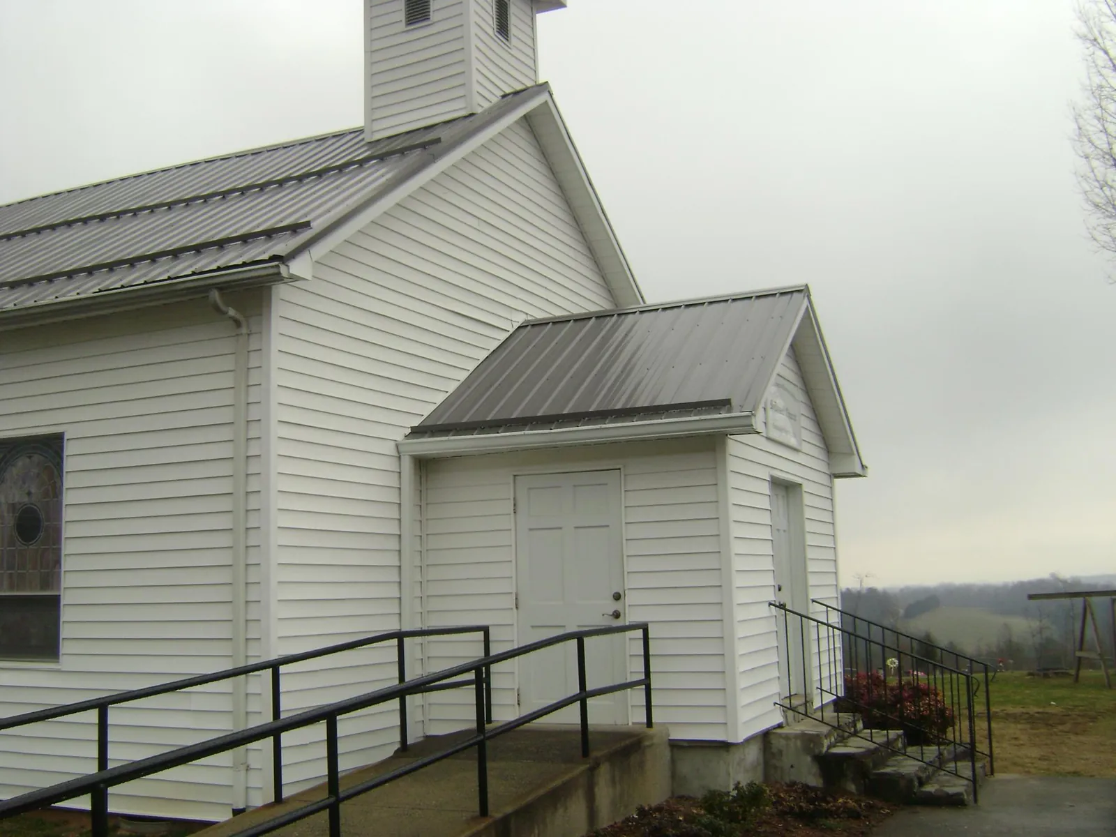 Gray metal roof on a white clapboard church with a steeple in Houston