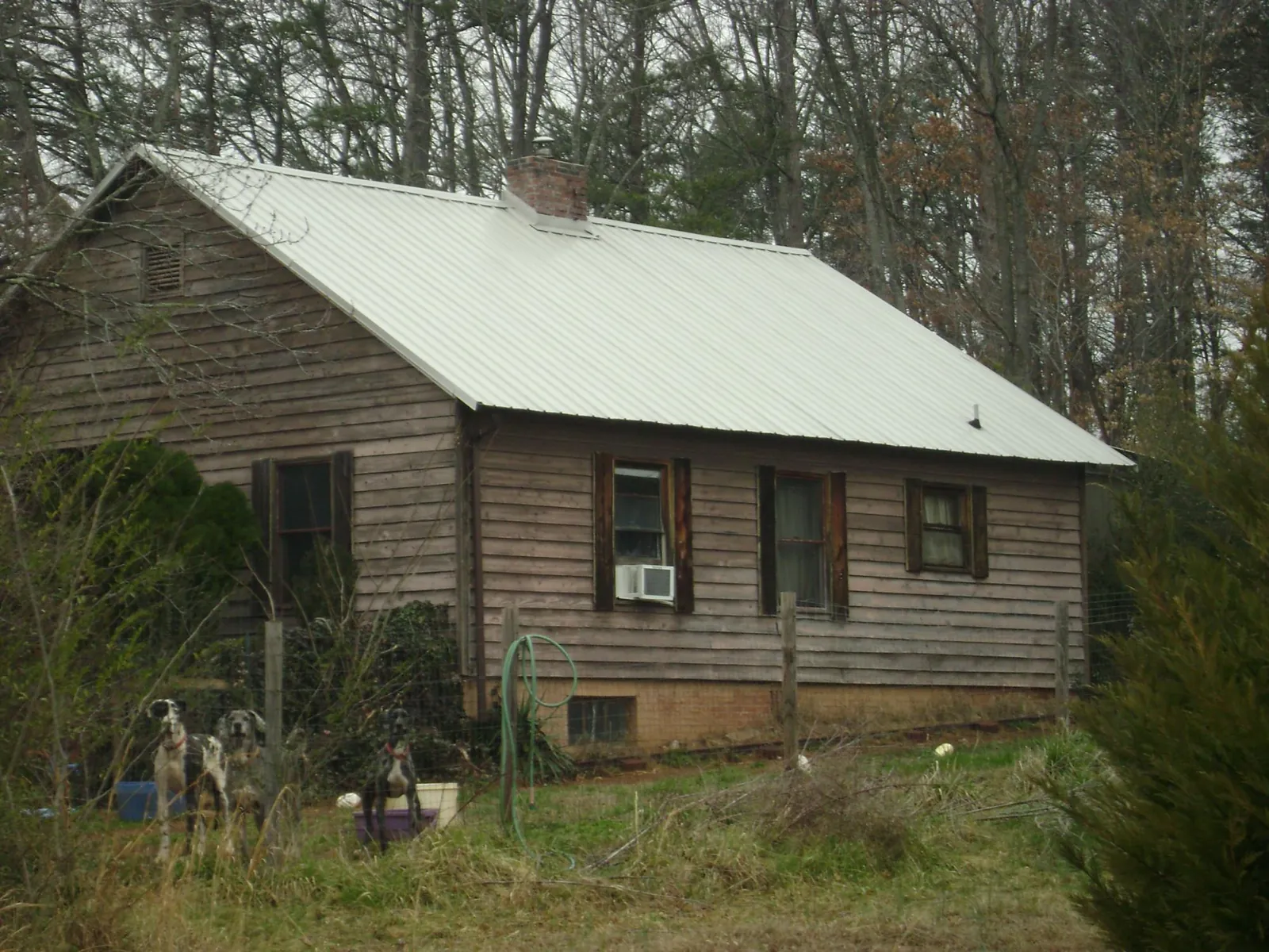 White metal roof on an old wood sided farmhouse, from a Metal Roof Installation job in Houston
